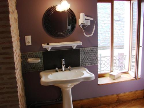 a bathroom with a sink and a mirror at L'Ancien Presbytère in Luzy