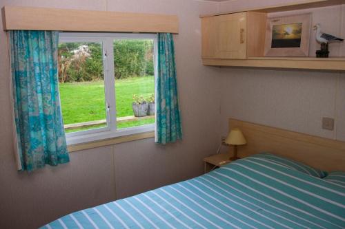 een slaapkamer met een bed en een raam bij Minicamping Hoeve het Tij in Vrouwenpolder