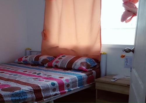 a bedroom with a bed with two pillows on it at Natcha Place Rangsit Donmuang in Ban Talat Rangsit