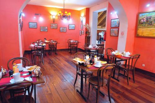- un restaurant avec des tables et des chaises dans une salle aux murs rouges dans l'établissement Rova Hotel, à Antananarivo