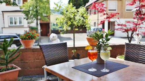 two wine glasses sitting on a table on a patio at Hotel Restaurant Falken in Baiersbronn