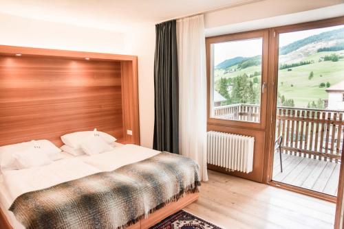 ein Schlafzimmer mit einem Bett und einem Balkon in der Unterkunft Hotel La Villa in Stern