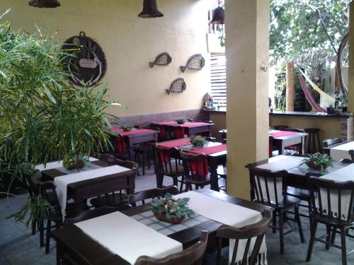 un restaurante con mesas y sillas en una sala con plantas en Pousada Lazer do Sol en Lucena