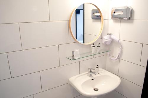 a bathroom with a sink and a mirror at Hotel Beez in Maastricht