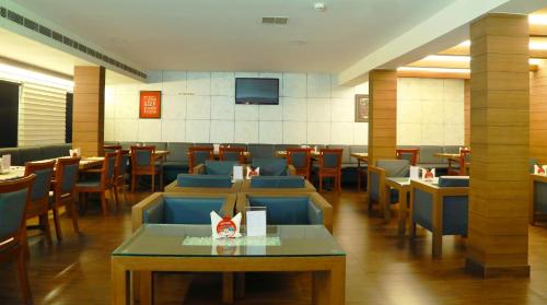 un restaurante con sillas y mesas azules y TV en Hotel Aquarius, en Vaikom
