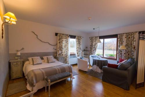 a bedroom with a bed and a living room at Hotel Llano Tineo in Villanueva de la Vera