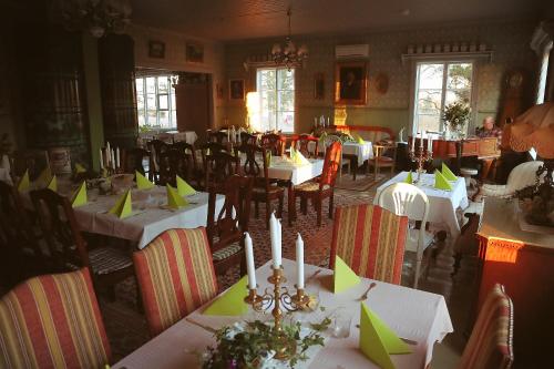 a dining room with tables and chairs with green napkins at Cirkus Hostel Holken in Inkoo
