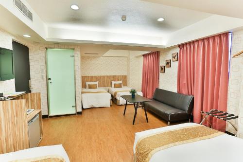 台北的住宿－北城大飯店，酒店客房,设有两张床和一张沙发