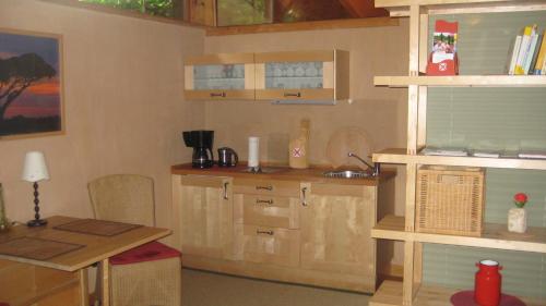 uma cozinha com armários de madeira, uma mesa e um balcão em Gästeappartement Appricot em Adendorf