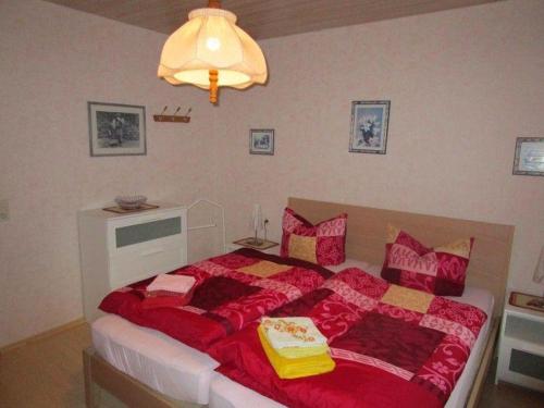 Haus-Kummeleck-Wohnung-3 في باد لوتربرغ: غرفة نوم بسرير كبير مع بطانيات ومخدات حمراء