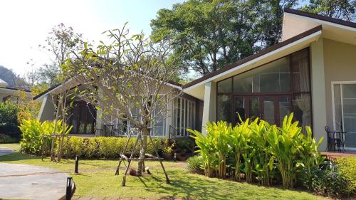 a house with a small tree in front of it at Arantarakiri Resort Khao Yai in Mu Si