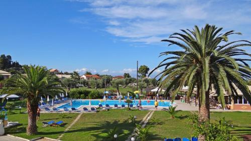 a resort with a swimming pool and palm trees at Egrypos Hotel in Petrití