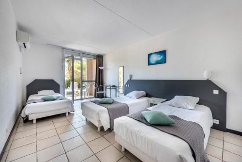 a hotel room with two beds and a balcony at Le Clos des Bruyères in Vallon-Pont-dʼArc