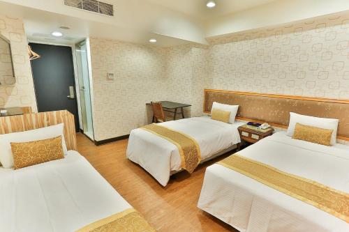 een hotelkamer met 2 bedden in een kamer bij City Hotel in Taipei