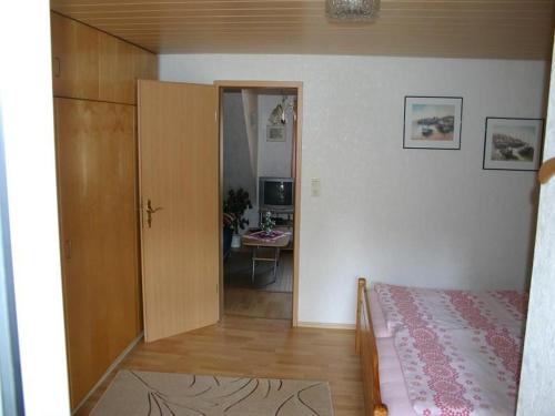 - une chambre avec un lit et une porte menant à une pièce dans l'établissement Haus-Kummeleck-Wohnung-1, à Bad Lauterberg