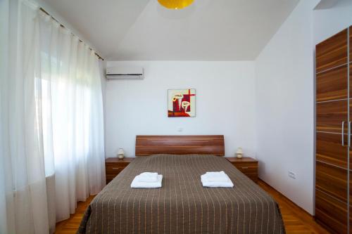 a bedroom with a bed with two towels on it at Royal Villas in Dobra Voda