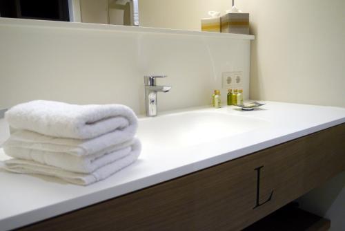 a bathroom with a white towel on a sink at Romantik Hotel Das Lindner in Bad Aibling