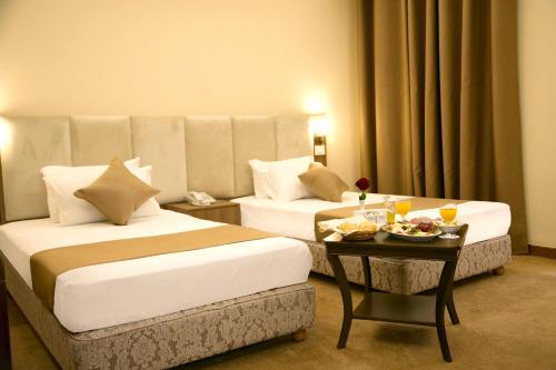 a hotel room with two beds and a table with food at Bzommar Palace Hotel in Harisa