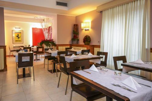 a restaurant with tables and chairs in a room at Hotel Master in Brescia