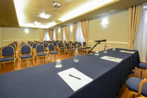 a conference room with a table and chairs and a microphone at Hotel Master in Brescia