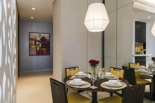 a dining room with a black table and chairs at Fraser Suites Riyadh in Riyadh
