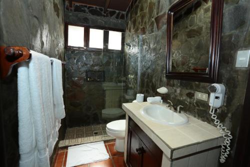 a bathroom with a sink and a toilet and a phone at Hotel Casa Colonial Boutique in Managua