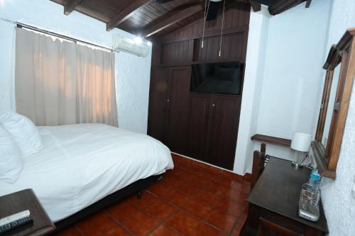 a bedroom with a bed and a television and a table at Hotel Casa Colonial Boutique in Managua