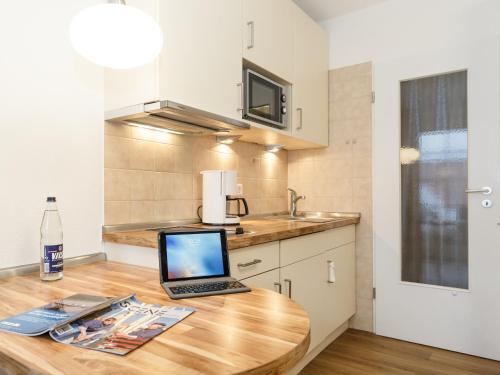a laptop computer sitting on top of a wooden table in a kitchen at Haus Wattenblick in Cuxhaven