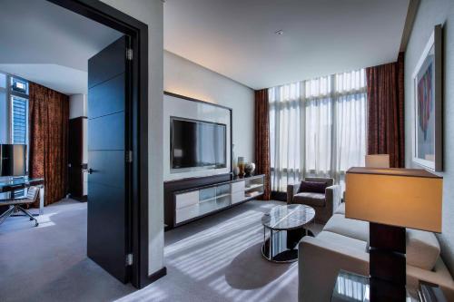 
a living room filled with furniture and a tv at Rosewood Abu Dhabi in Abu Dhabi
