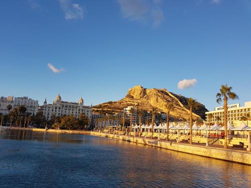 Blick auf einen Fluss mit Gebäuden und einen Berg in der Unterkunft Alicante old city & beach appartment in Alicante