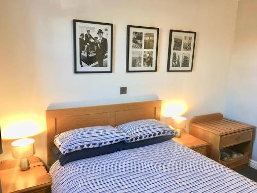 a bedroom with a bed with three pictures on the wall at Globe Inn in Tamworth