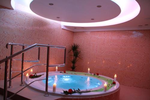 een hot tub in een kamer met kaarsen bij Villa Martini in Międzyzdroje