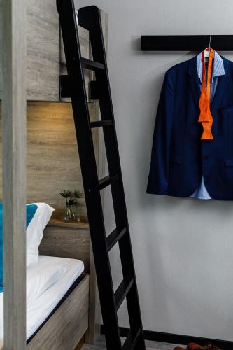 a bunk bed with a suit hanging on a wall at Hotell Nissastigen in Gislaved