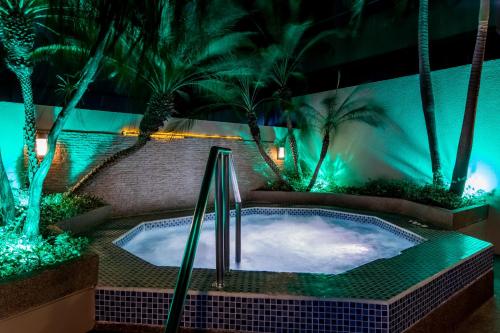 a swimming pool at night with palm trees and lights at Wyndham Garden Guayaquil in Guayaquil