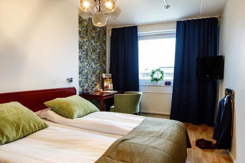 a hotel room with two beds and a window at Hotell Nissastigen in Gislaved