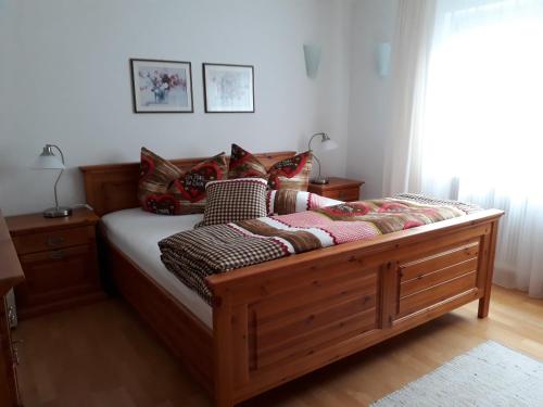 a bed with a wooden frame in a room at Haus Sonnenheim in Frastanz