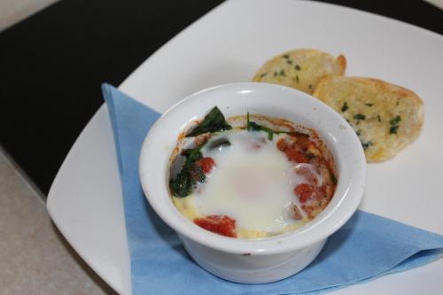 a bowl of soup on a white plate with bread at Mincombe Barn Bed & Breakfast in Sidbury