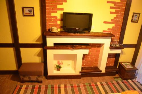 a living room with a fireplace with a flat screen tv at Fachwerk in Yaremche