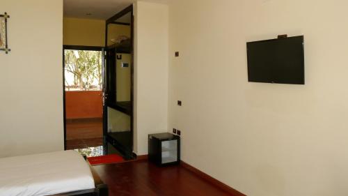 Una habitación con una cama y un televisor en una pared. en Zagwe Hotel, en Lalibela