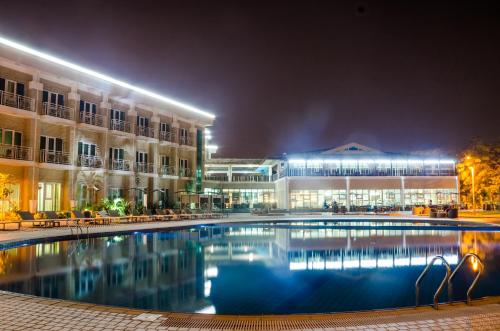 a large pool in front of a building at night at Pefaco Hotel Maya Maya in Brazzaville