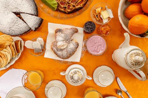 een tafel met brood en andere ontbijtproducten en -dranken bij Locanda Etrusca in Bibbona