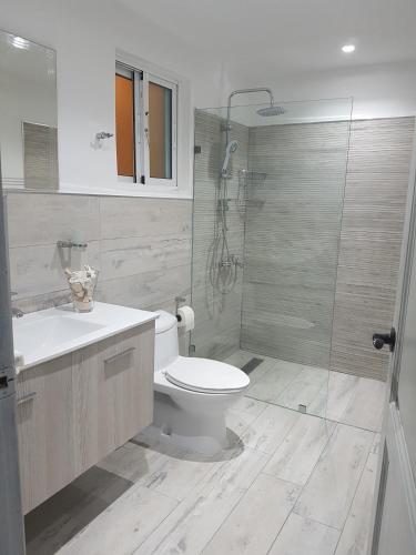 a bathroom with a toilet and a glass shower at Cadaques Caribe Pez 103 in Bayahibe