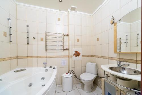 a bathroom with a tub and a toilet and a sink at Apartments on Darnitsa in Kyiv