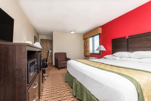 a hotel room with two beds and a flat screen tv at Days Inn by Wyndham Muncie -Ball State University in Muncie