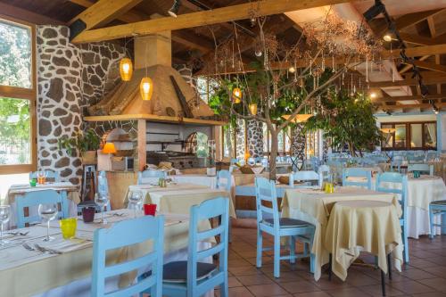 un restaurante con mesas blancas y sillas azules en Da Renzo en Siamaggiore