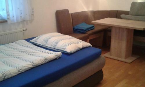 a bed sitting in a room with a table at Ferienwohnung Susanne in Ulrichsberg