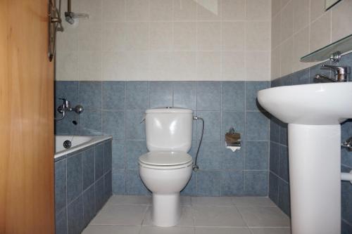 uma casa de banho com um WC branco e um lavatório. em Aurora Townhouse - Complimentary Paphos Airport Transport em Pafos