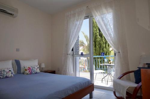 a bedroom with a bed and a large window at Aurora Townhouse - Complimentary Paphos Airport Transport in Paphos City
