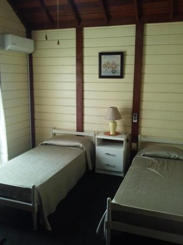 Habitación con 2 camas y mesa con lámpara. en El Repecho, en Piriápolis