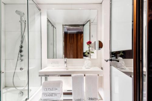 a bathroom with a sink, mirror and bath tub at Hotel Granados 83, a Member of Design Hotels in Barcelona